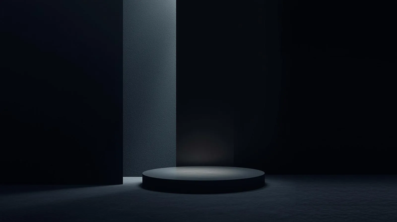 Dark room with a circular podium and narrow opening of light.